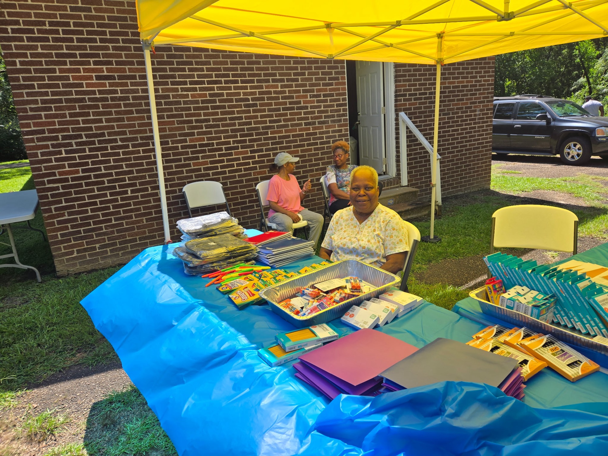 Volunteers sharing school supplies at an outdoor community giveaway